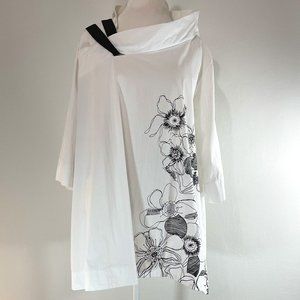 White tunic with floral ornament and asymmetrical collar.